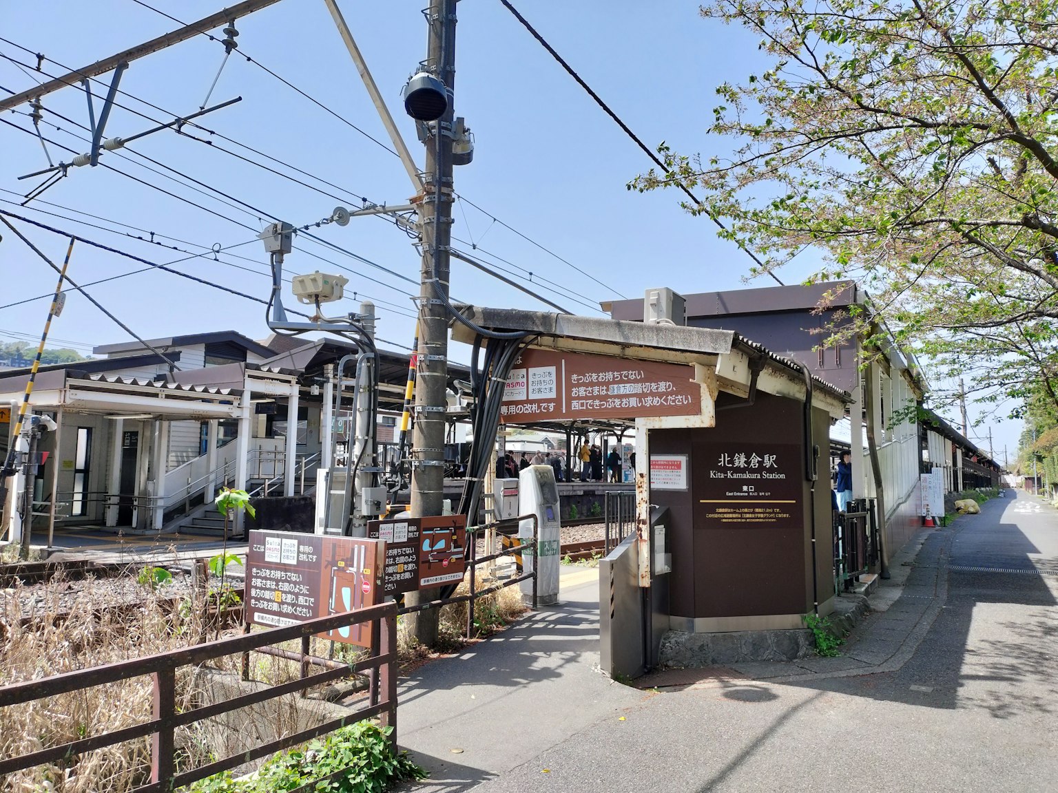 Sunny day view of a train station entrance and railway tracks