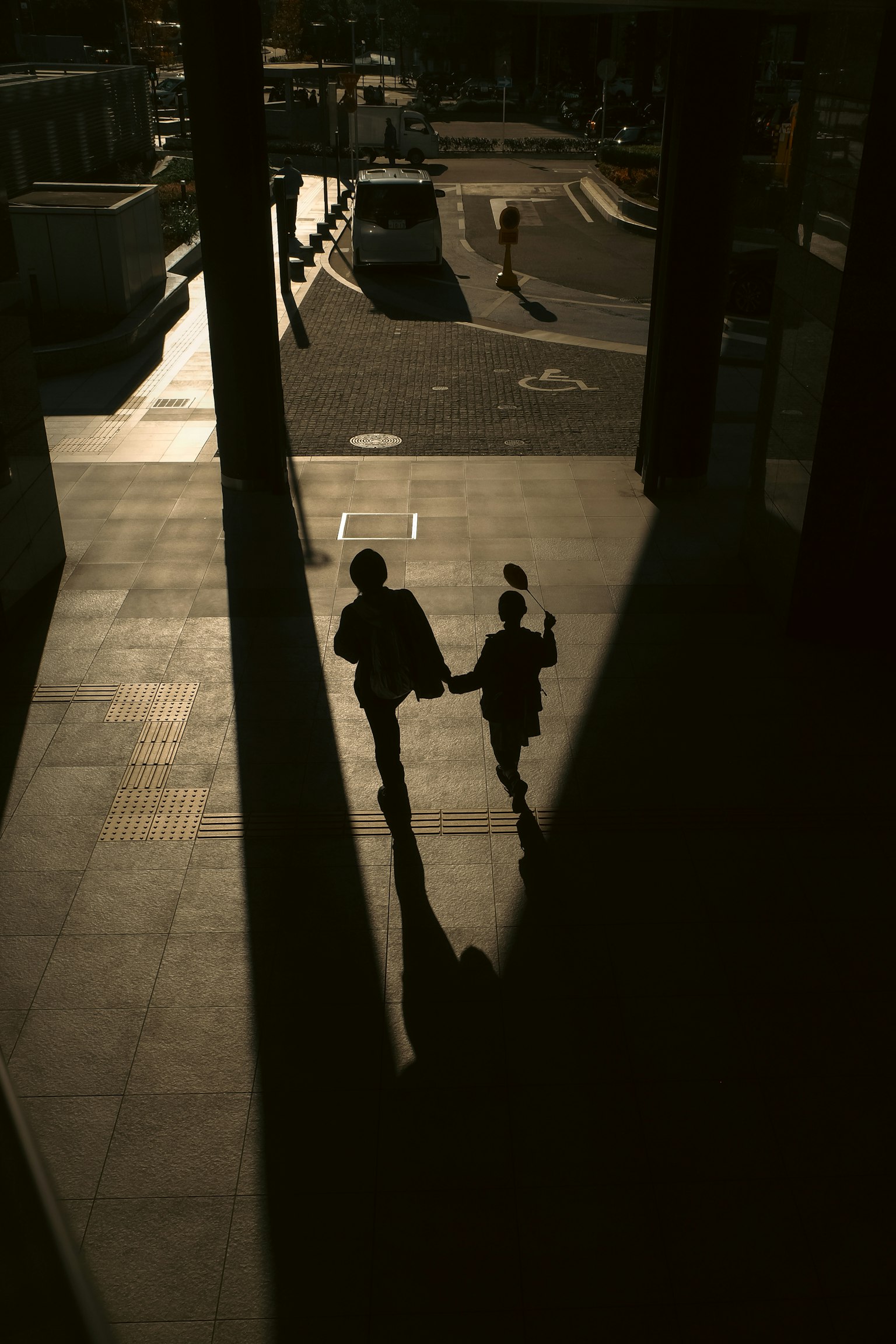 影の中で手をつないで歩く二人のシルエット