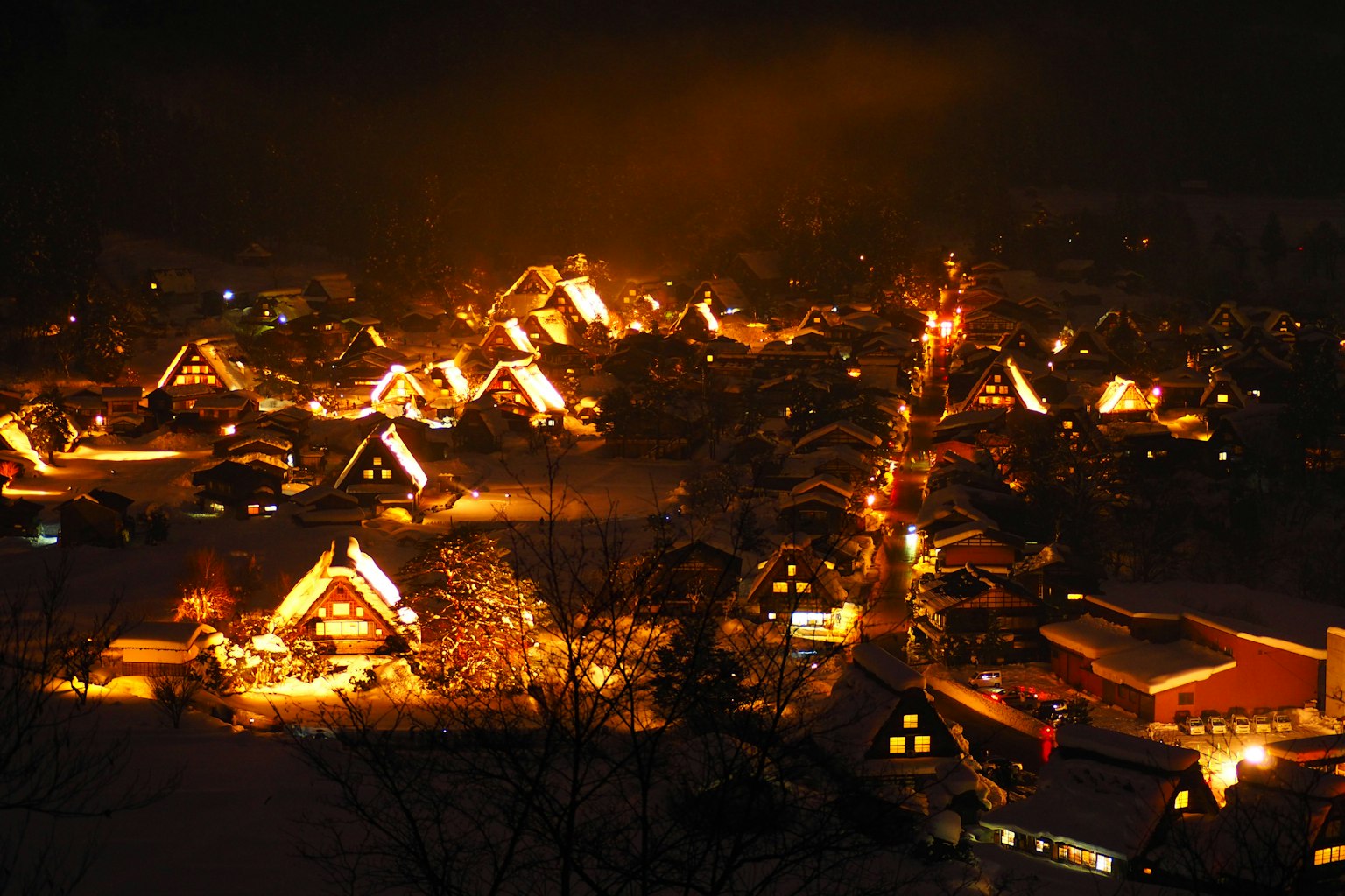ทิวทัศน์หมู่บ้านในคืนฤดูหนาวที่มีบ้านหลังคาหญ้าแฝกสว่างไสว