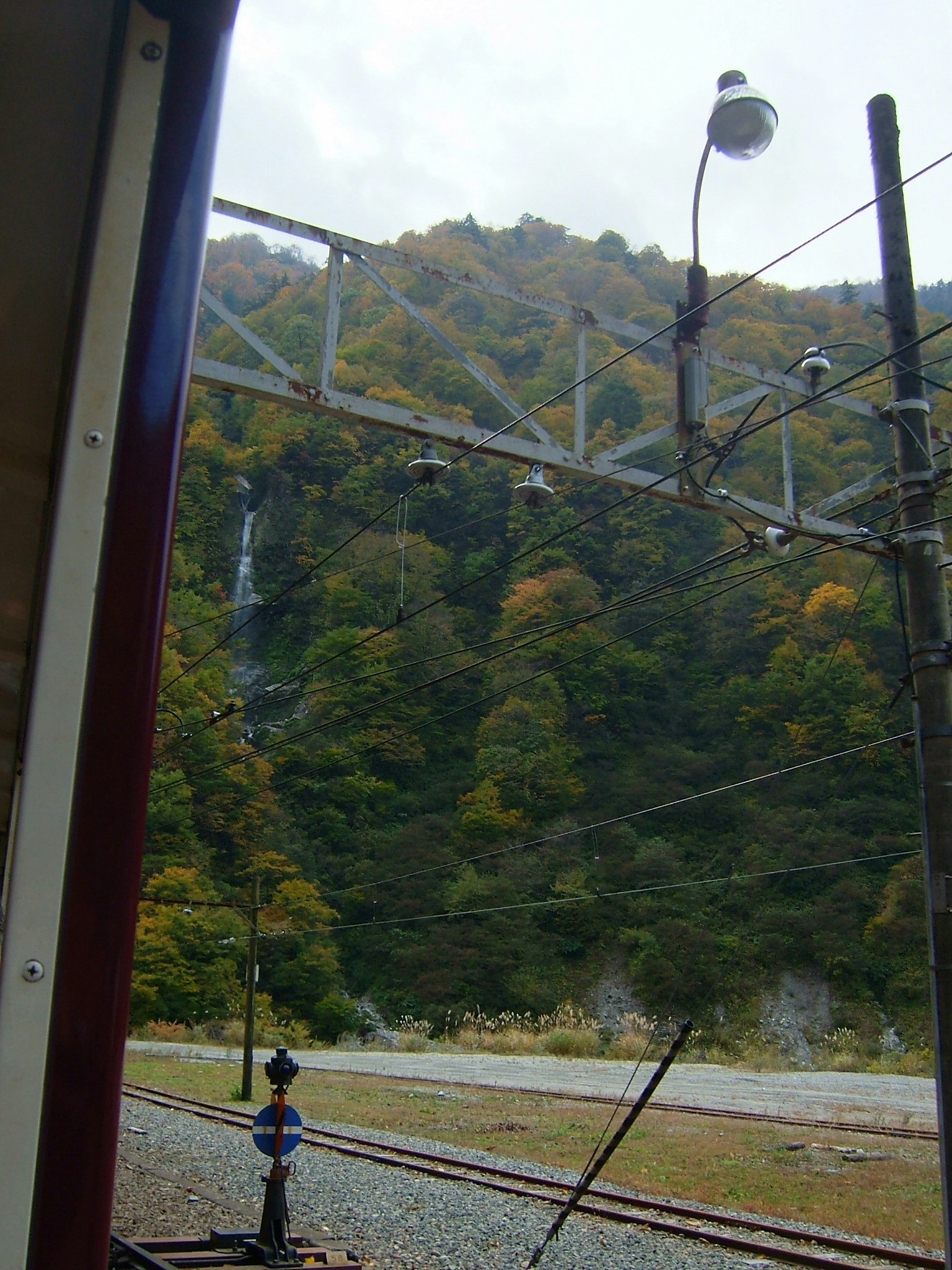 Vista di montagne e una cascata da una finestra di treno