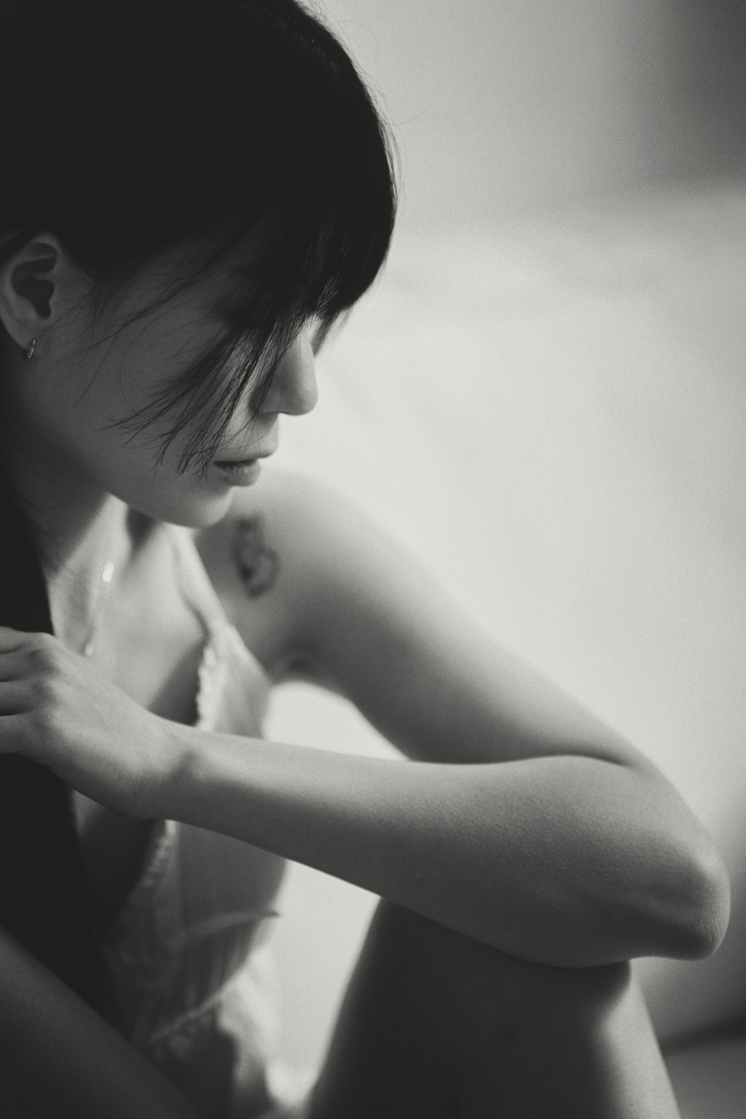 側身的女性黑白照片 長髮垂在肩上 可見的紋身