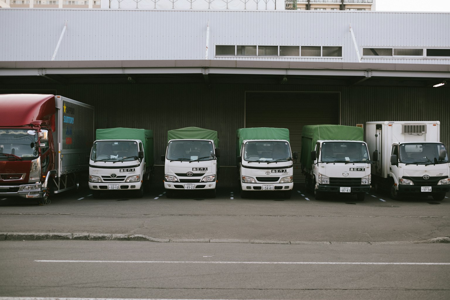 A lineup of various delivery trucks parked in a lot
