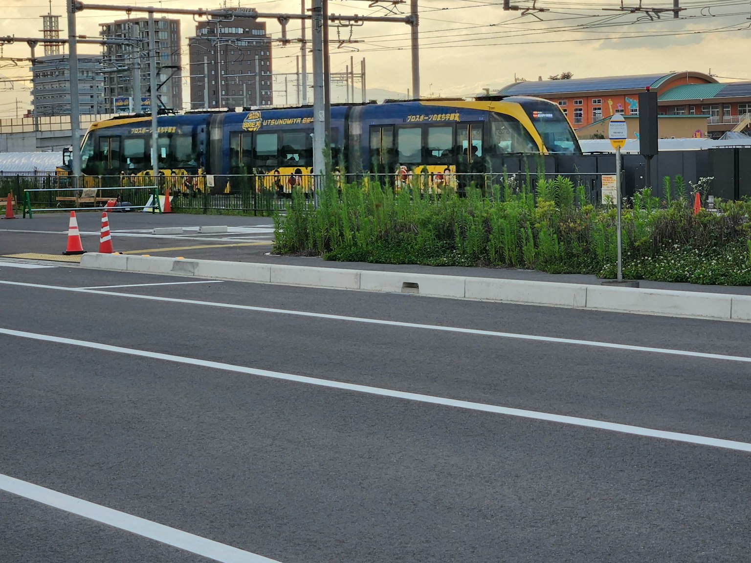 Gelber und blauer Straßenbahnwagen, der in der Nähe der Gleise mit umliegenden Gebäuden parkt