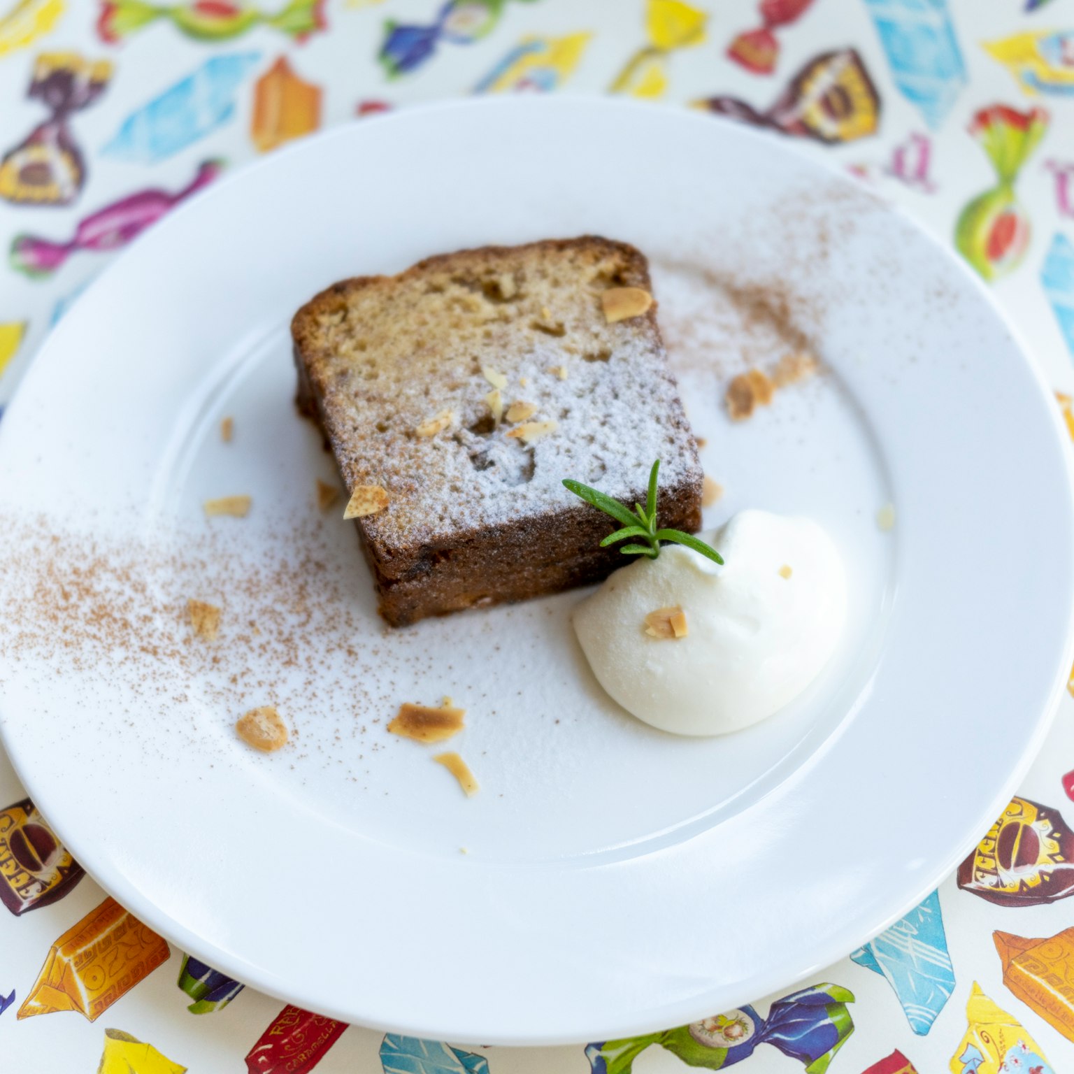 Fetta di dessert su un piatto con panna montata e un rametto di menta