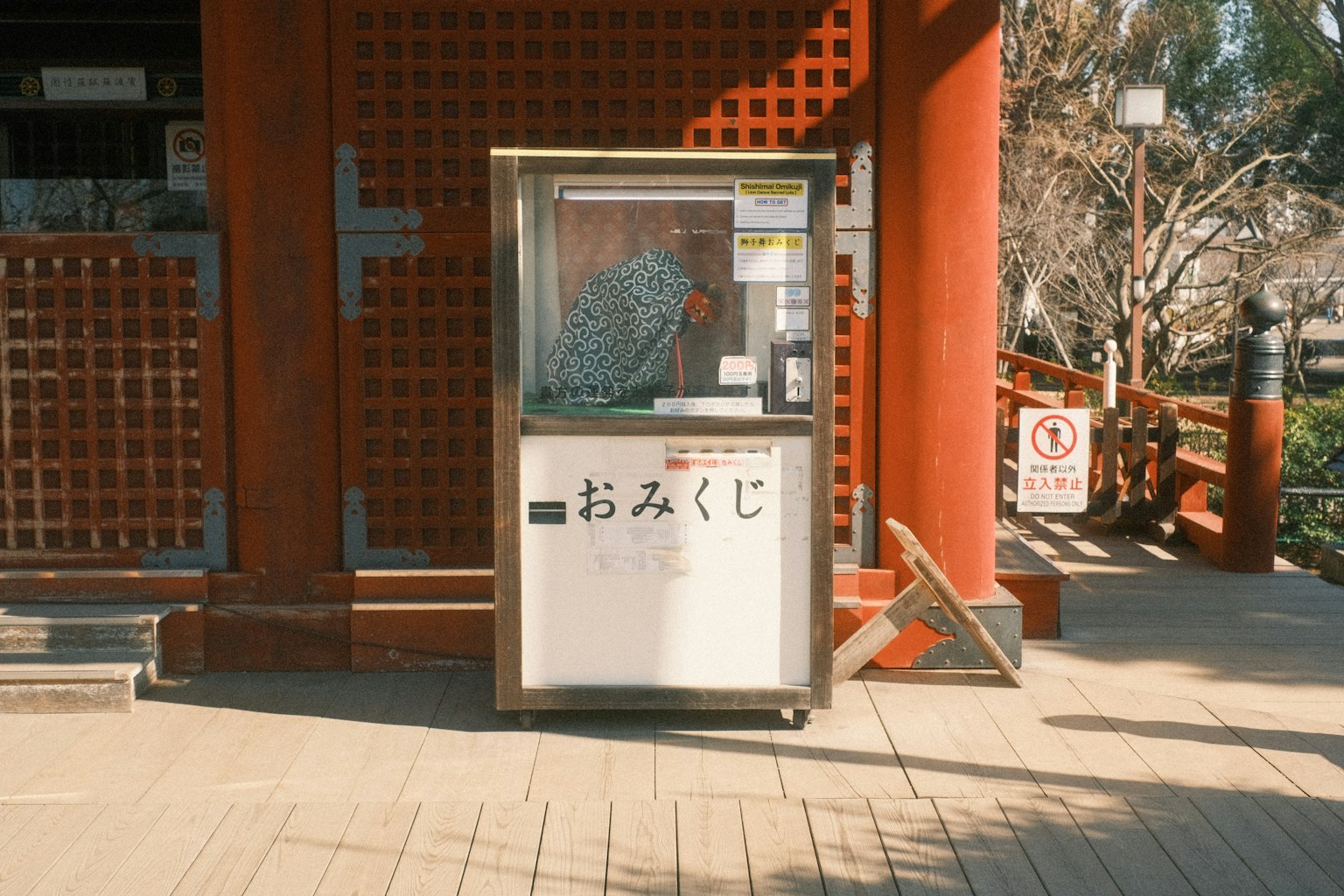 Mesin omikuji di depan gedung merah