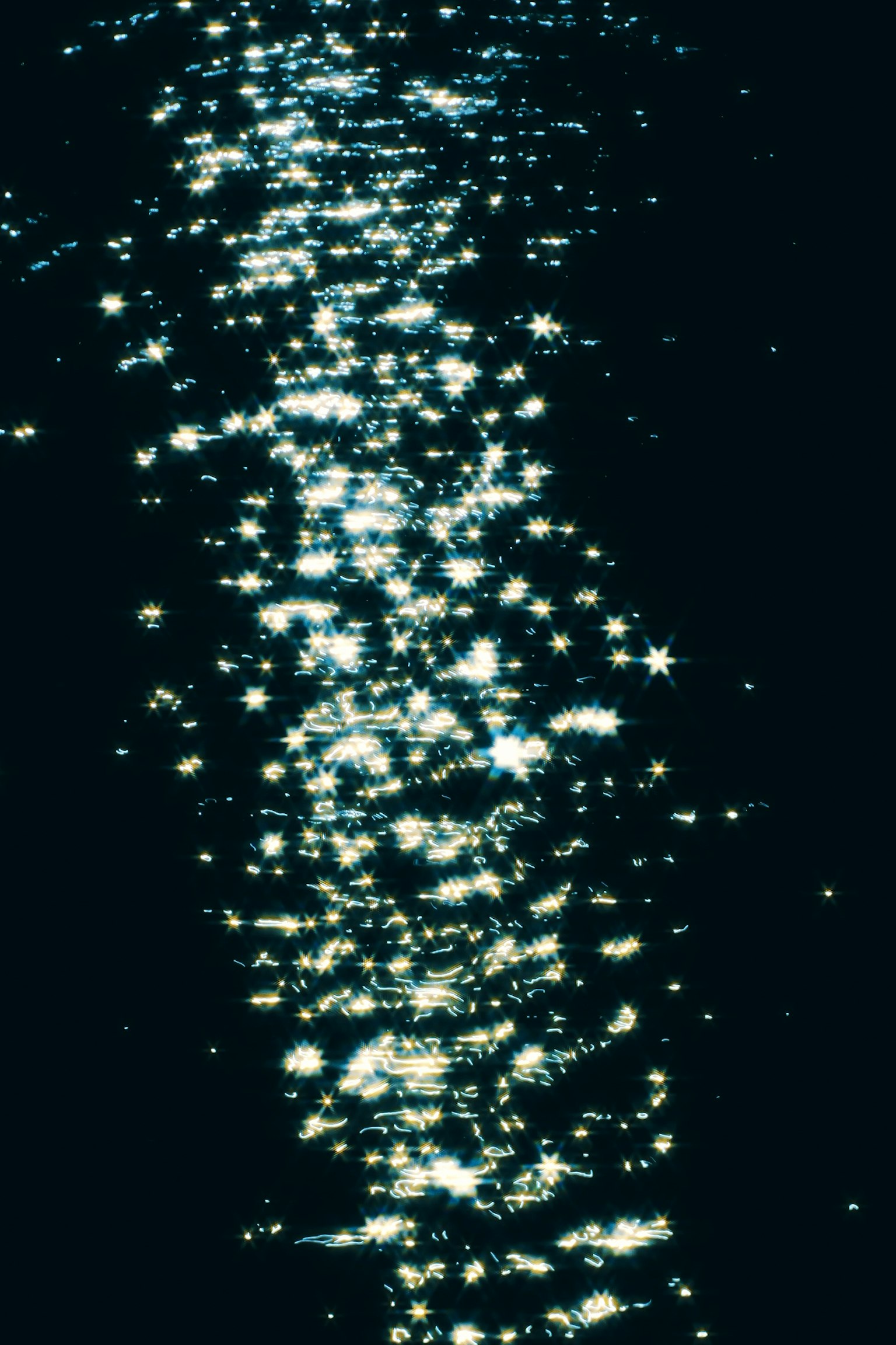 水面に反射する光の点が美しい暗い背景の画像