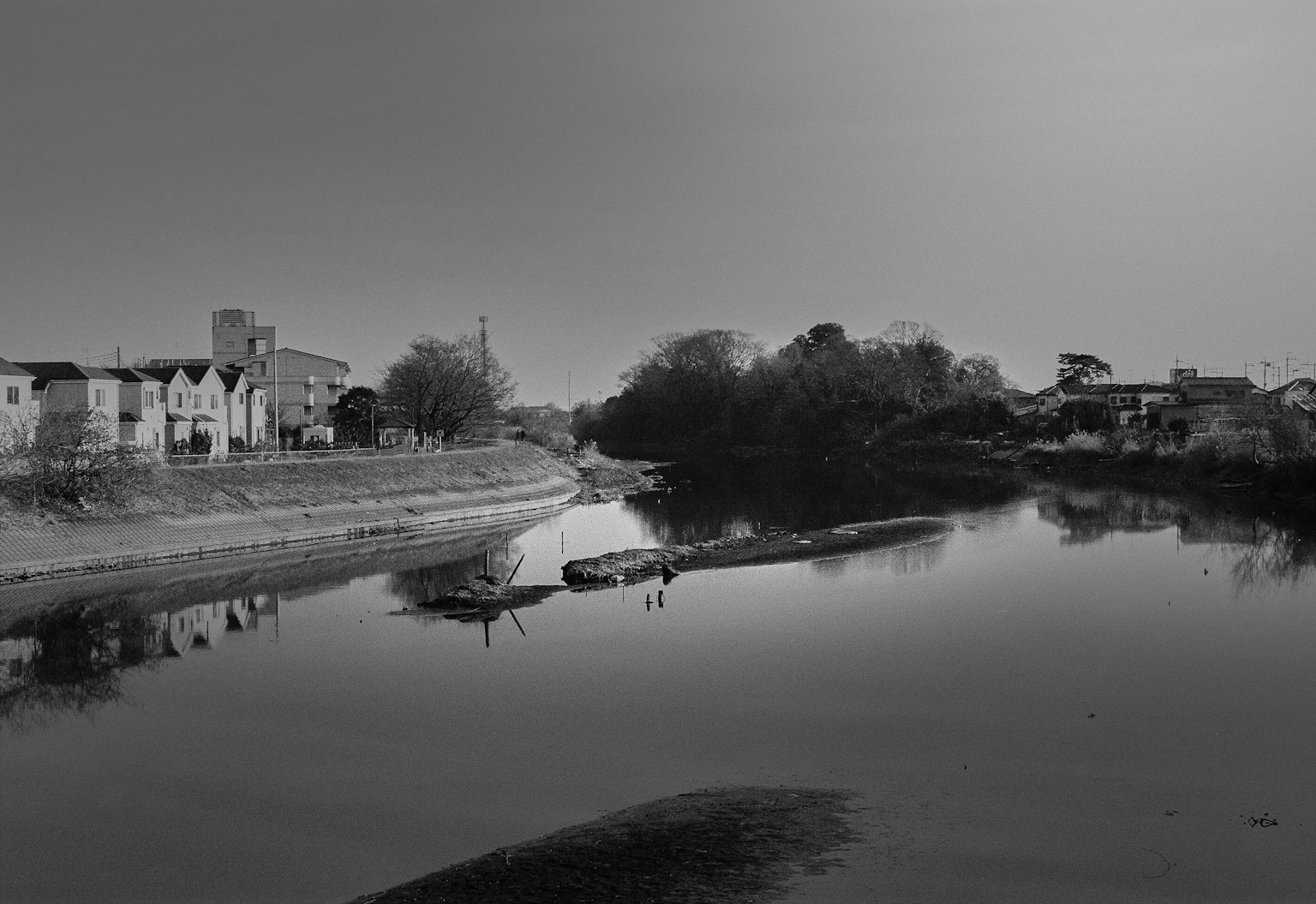 Monochromes Flusslandschaft mit reflektierten Gebäuden in der Nähe