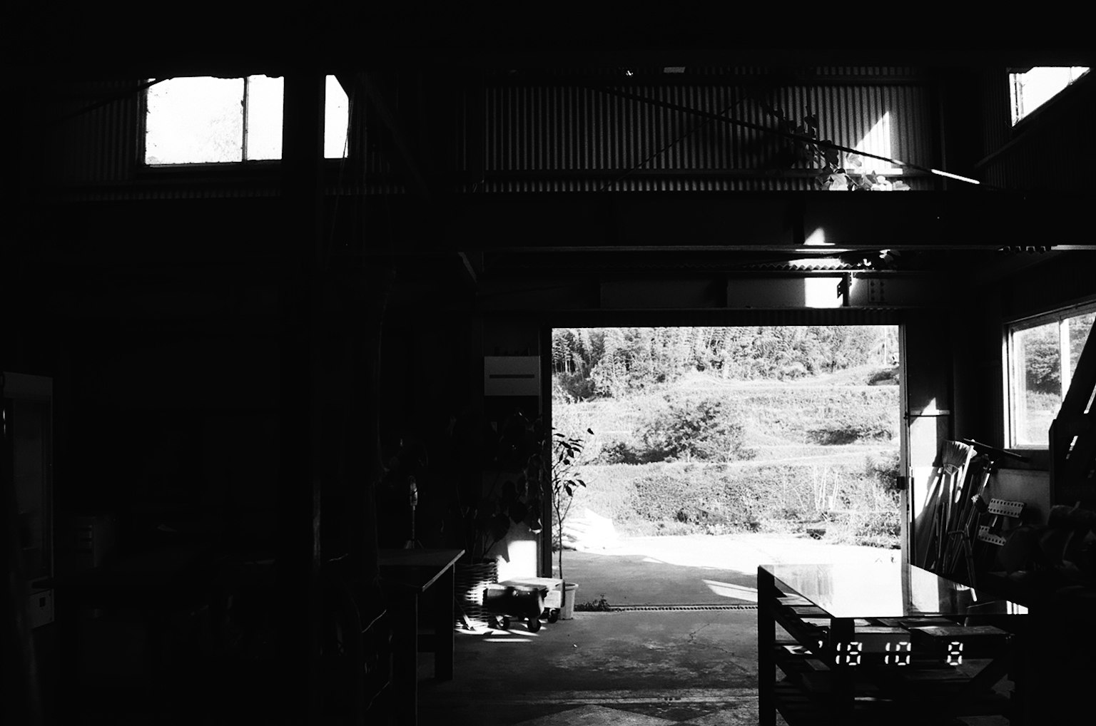 Interior of a dark workshop showing the view outside