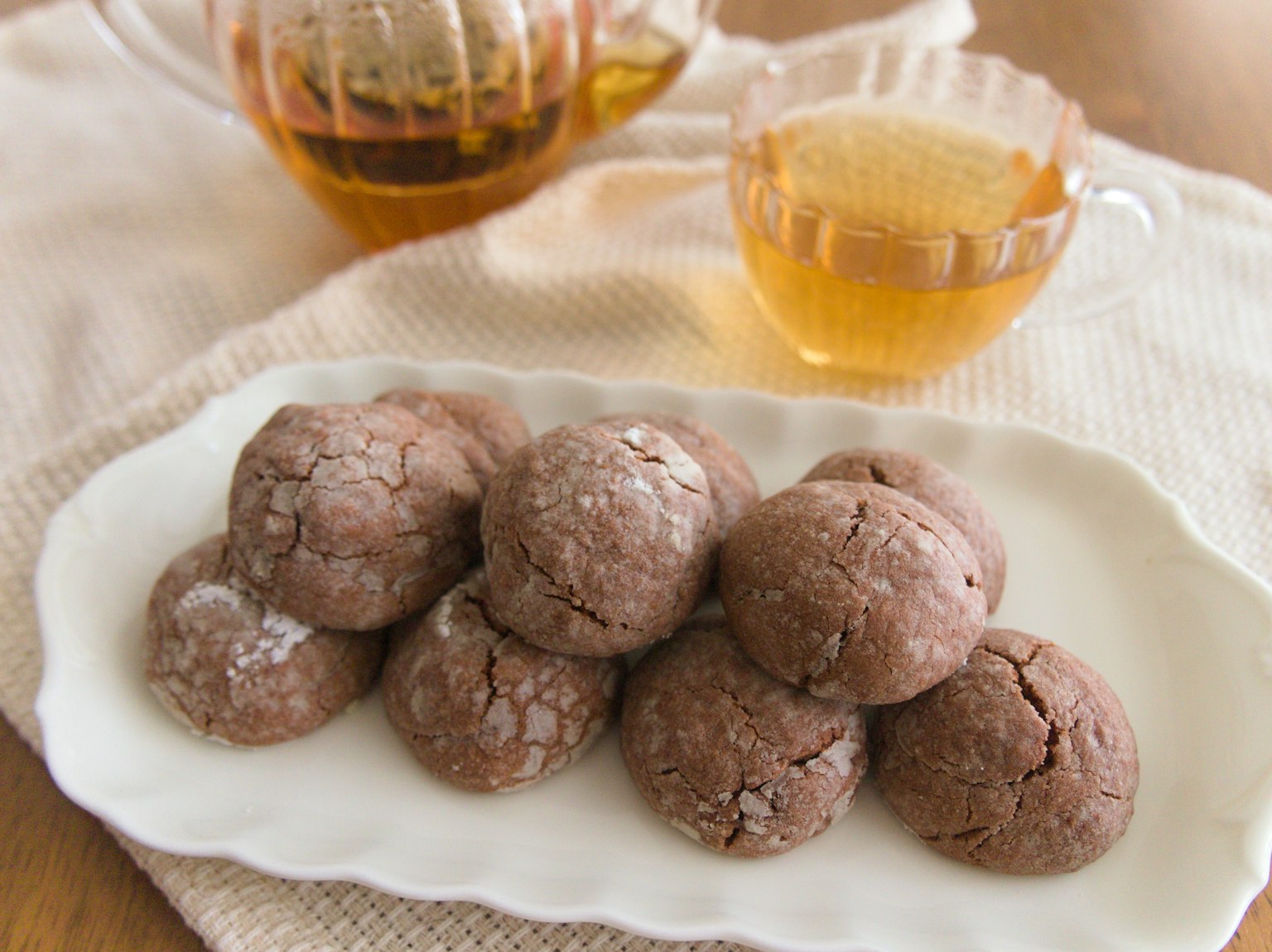 Susunan teh dan kue yang indah kue cokelat di piring perak dengan cangkir teh bening