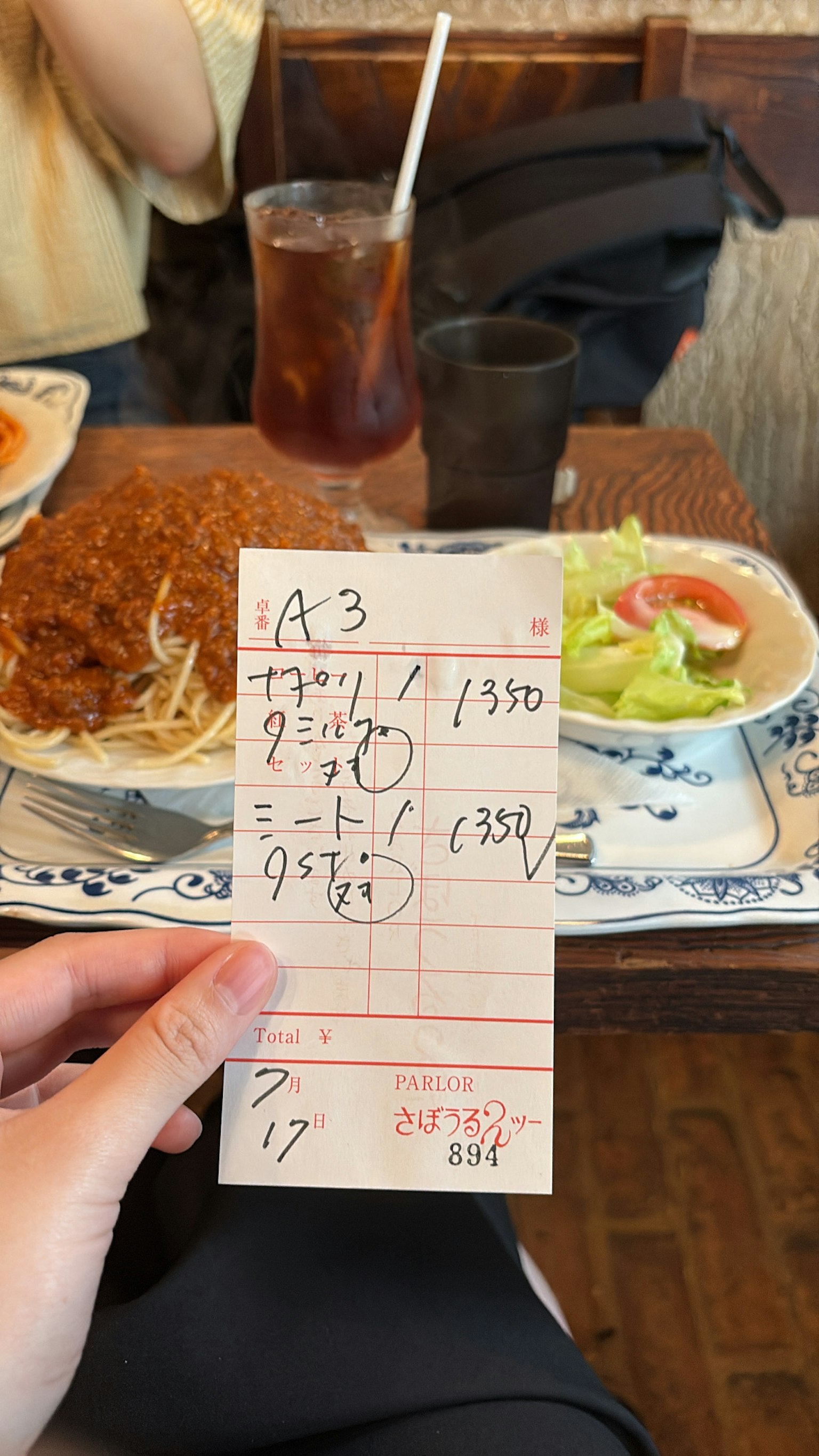 Một bàn có đĩa thức ăn và một hóa đơn viết tay