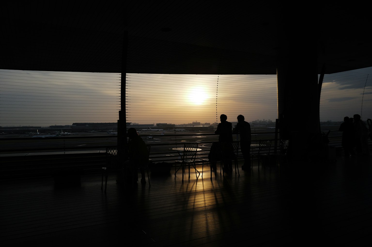 เงาคนที่มองพระอาทิตย์ตกจากเลานจ์สนามบิน