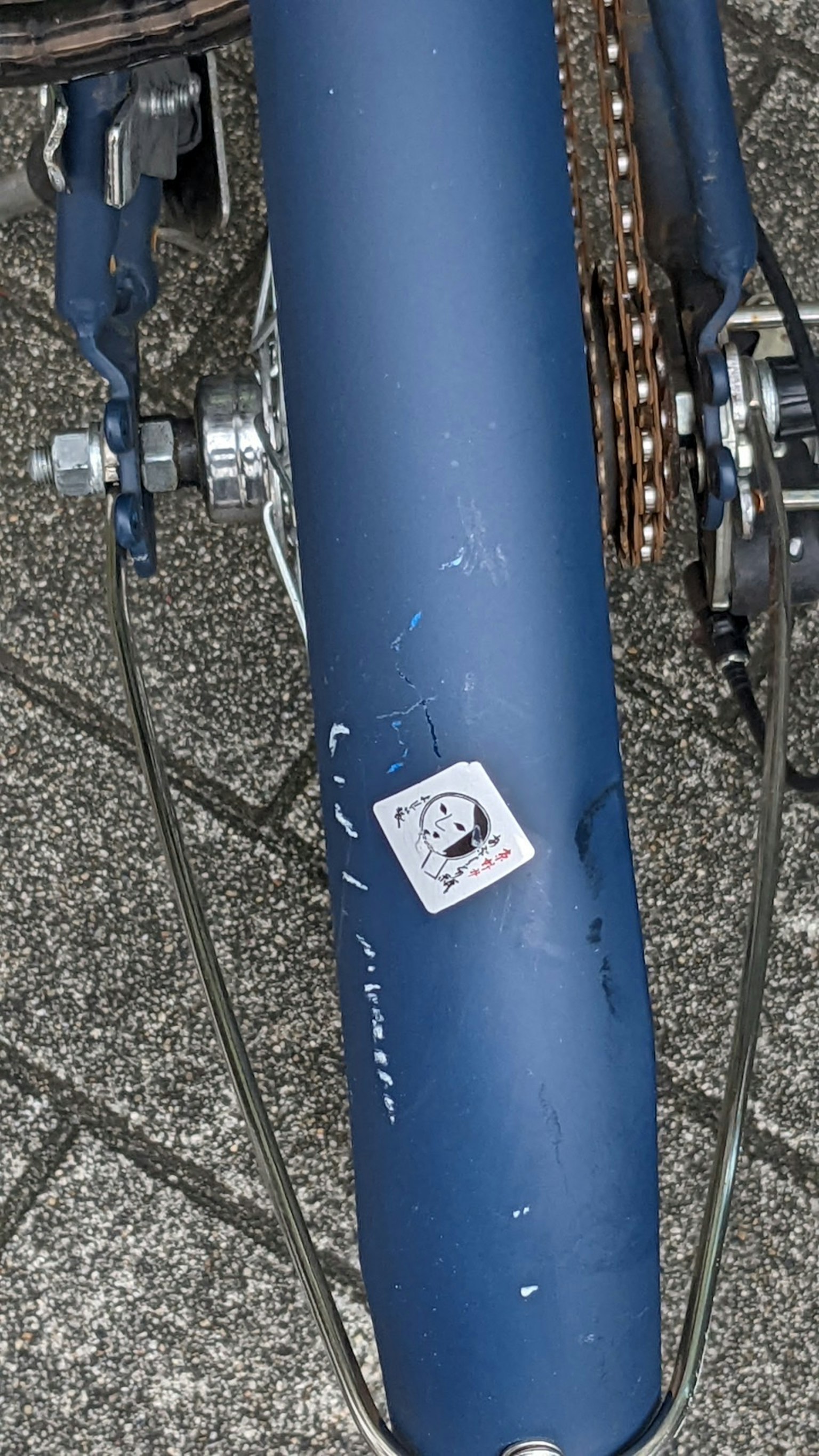 Gros plan sur un cadre de vélo bleu avec des engrenages et un autocollant