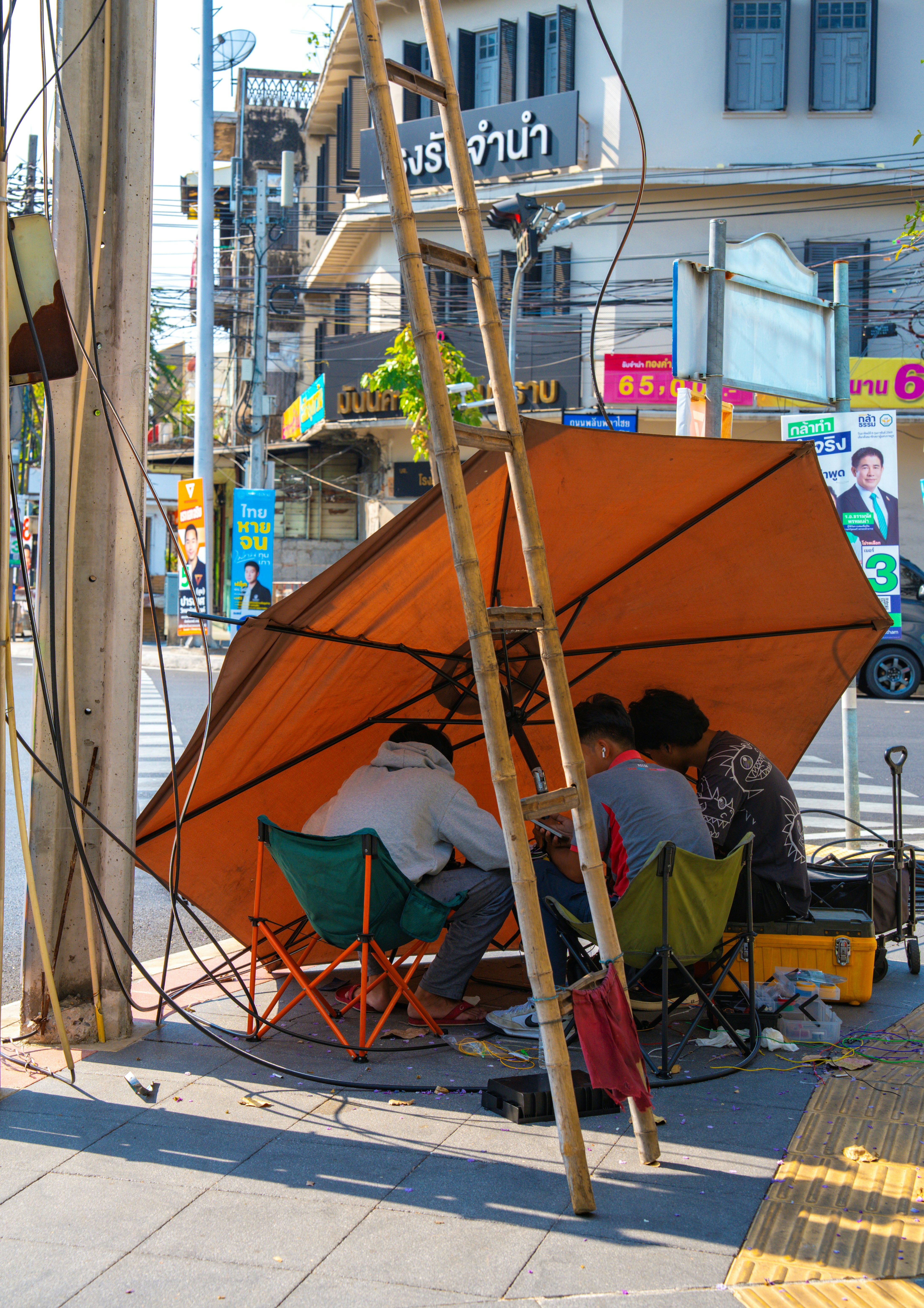 タイのバンコクの路地で屋台のテントと配線が並ぶ街角の風景